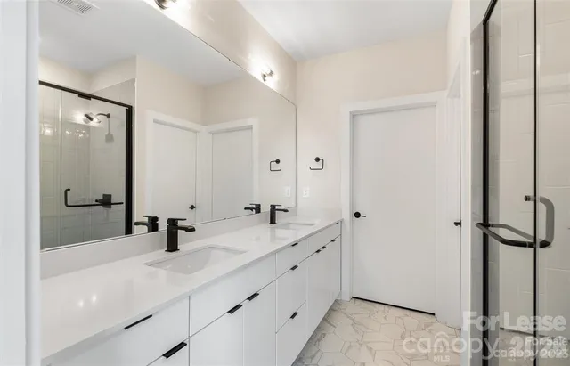 a bathroom with a double vanity sink and mirror