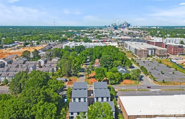 an aerial view of residential houses with outdoor space and trees