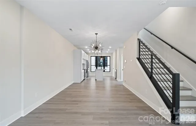 a view of a hallway with wooden floor and staircase