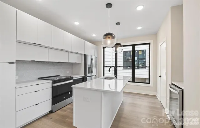 a large kitchen with stainless steel appliances kitchen island granite countertop a sink and cabinets