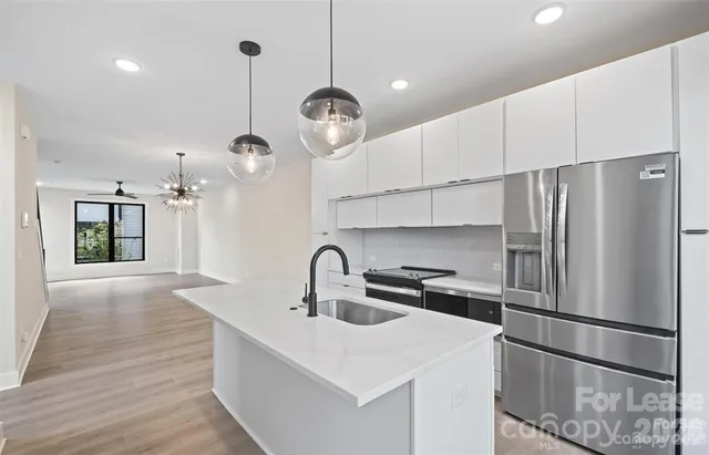 a kitchen with refrigerator cabinets and wooden floor