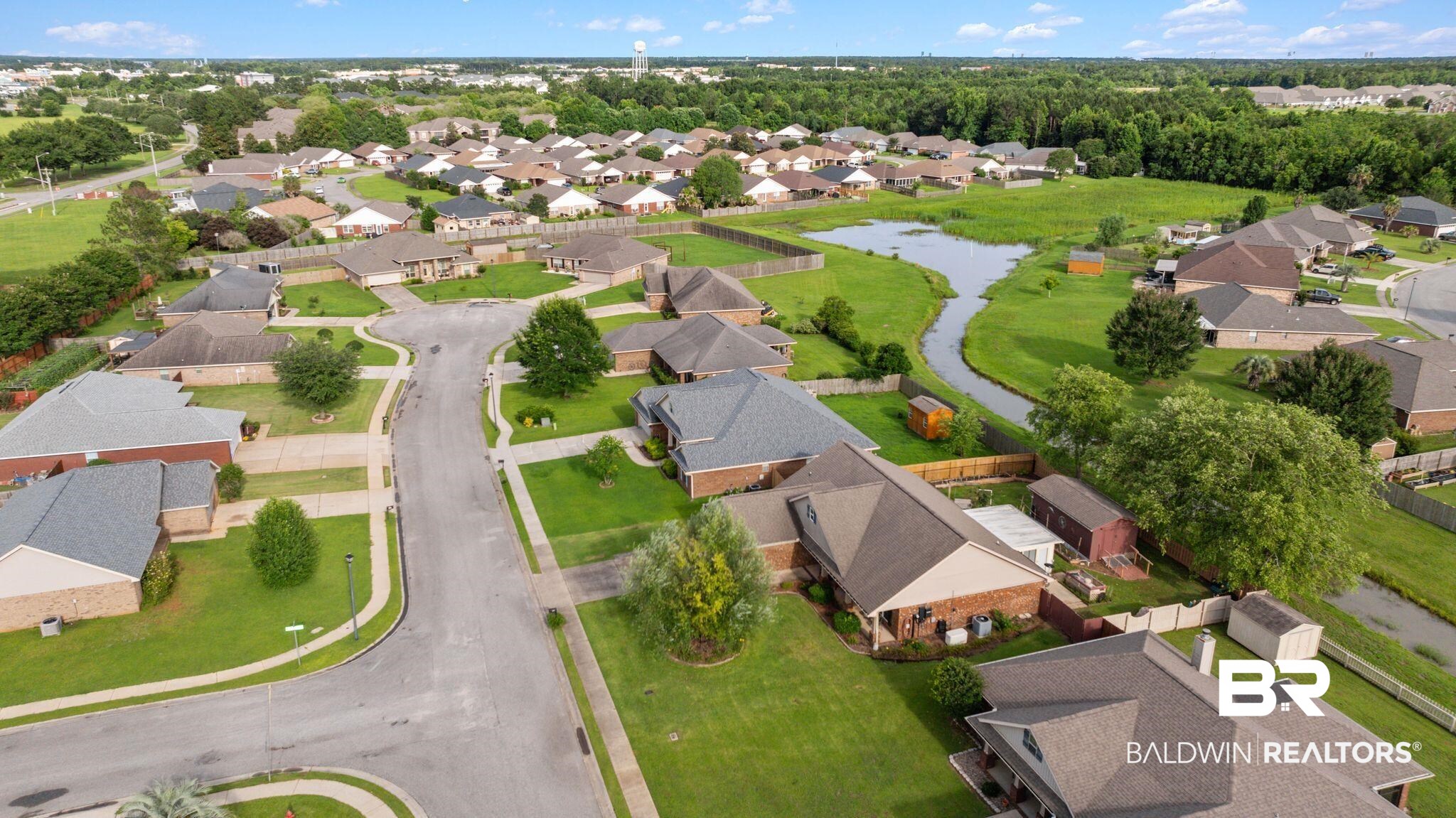 562 Vestige Mews Foley, AL 36535 - Photo 53 of 54 Aerial overview of a residential neighborhood featuring single-story homes with shingle roofs, manicured lawns, and mature trees