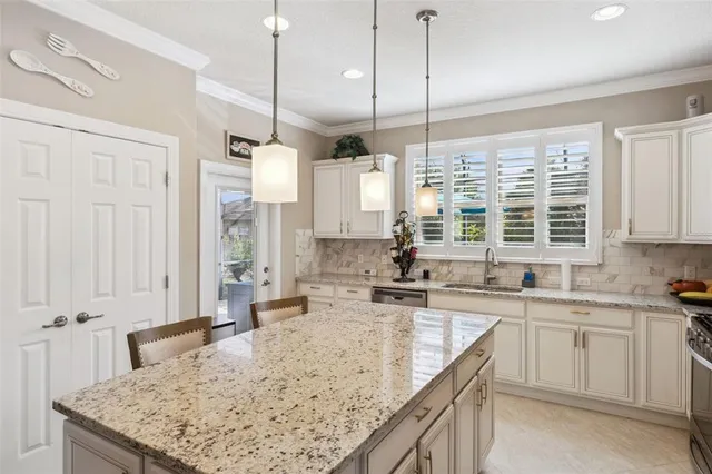a kitchen with stainless steel appliances granite countertop sink stove and white cabinets with wooden floor