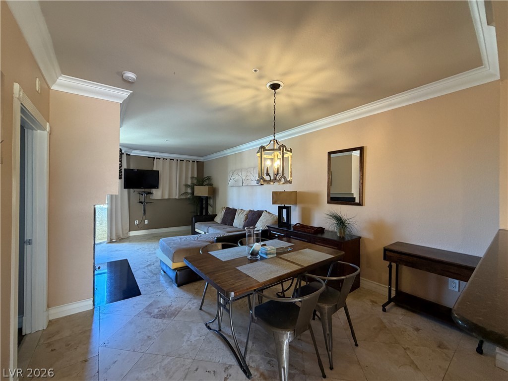 210 East Flamingo Road, Unit 426 Las Vegas, NV 89169 - Photo 5 of 17 Elegant crown molding graces the dining area, featuring an open layout and tiled flooring.
