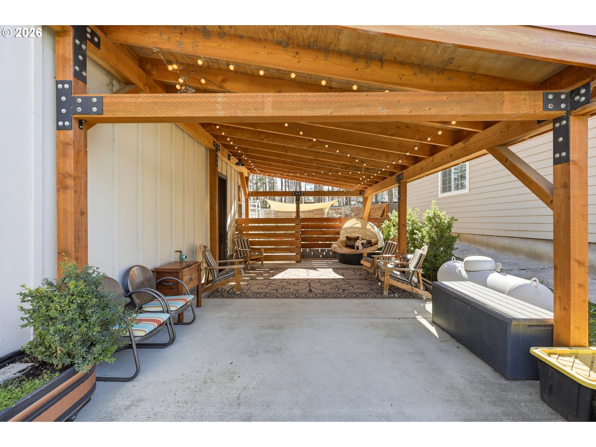 206 South Lakewood Road Tygh Valley, OR 97063 - Photo 8 of 48 a view of a patio with couches chairs potted plants and floor to ceiling window