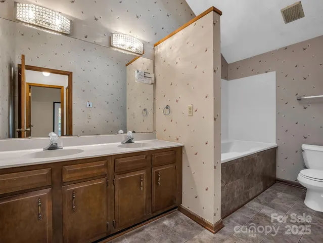 a spacious bathroom with a granite countertop sink mirror and toilet