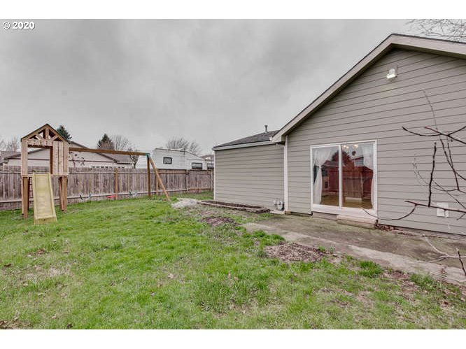 500 Toliver Road Molalla, OR 97038 - Photo 23 of 25 a view of a backyard with plants and brick wall