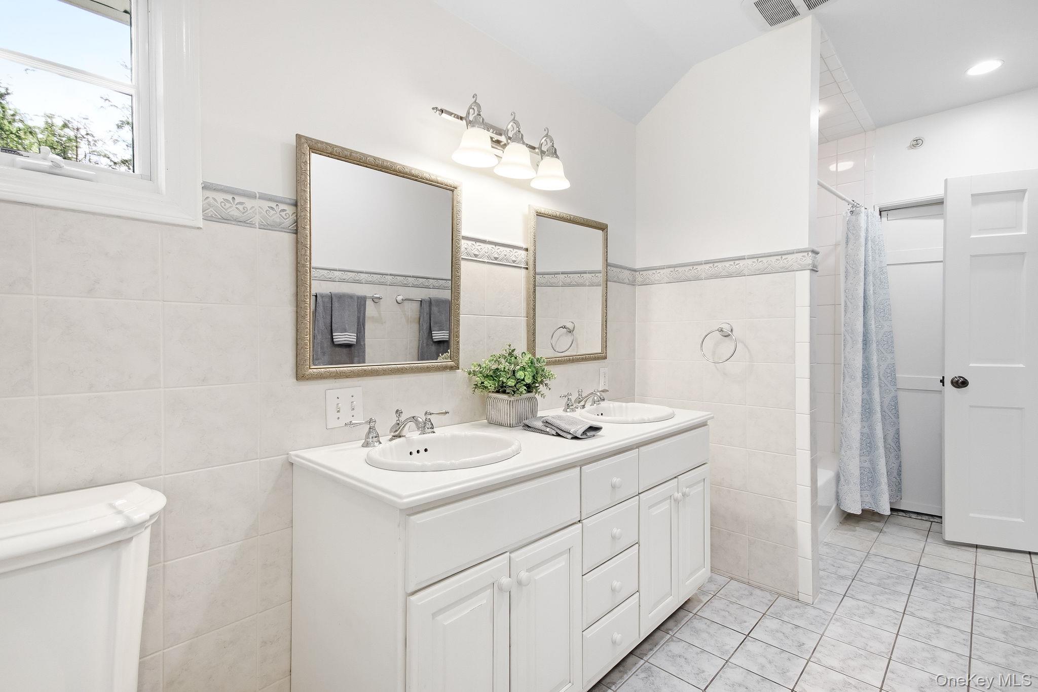 26 Century Ridge Road Purchase, NY 10577 - Photo 25 of 50 Dual sink vanity with white cabinetry and chrome fixtures, illuminated by a three-light fixture (Bathroom #4)