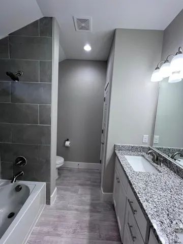 a bathroom with a granite countertop double vanity sink and mirror