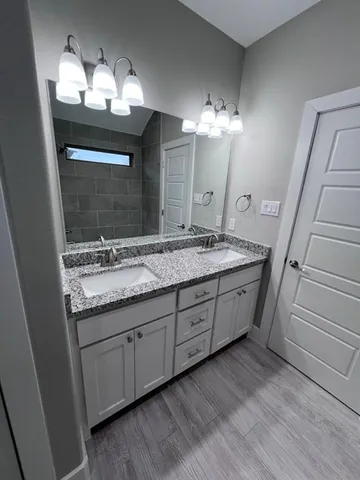a bathroom with a double vanity sink and a mirror