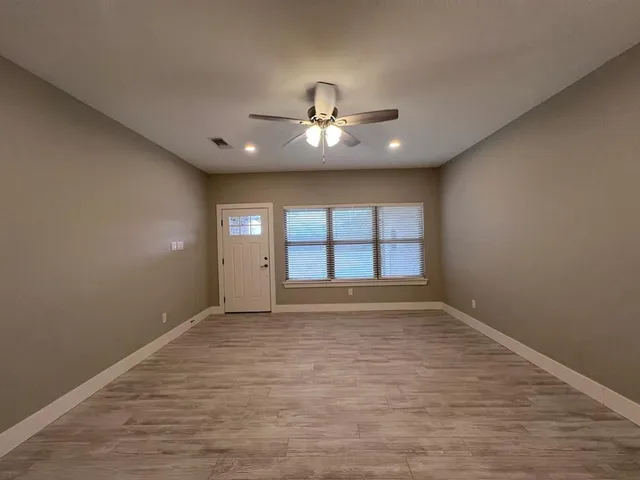 wooden floor in an empty room with a window