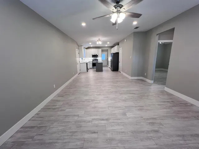 a view of a livingroom with a ceiling fan and hardwood floor