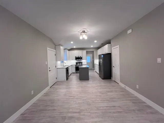 a view of a kitchen with a sink and a refrigerator