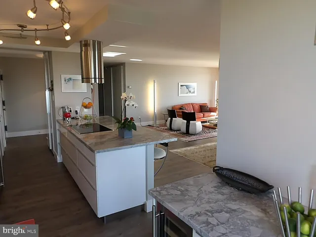 a kitchen with stainless steel appliances kitchen island granite countertop a table and chairs in it