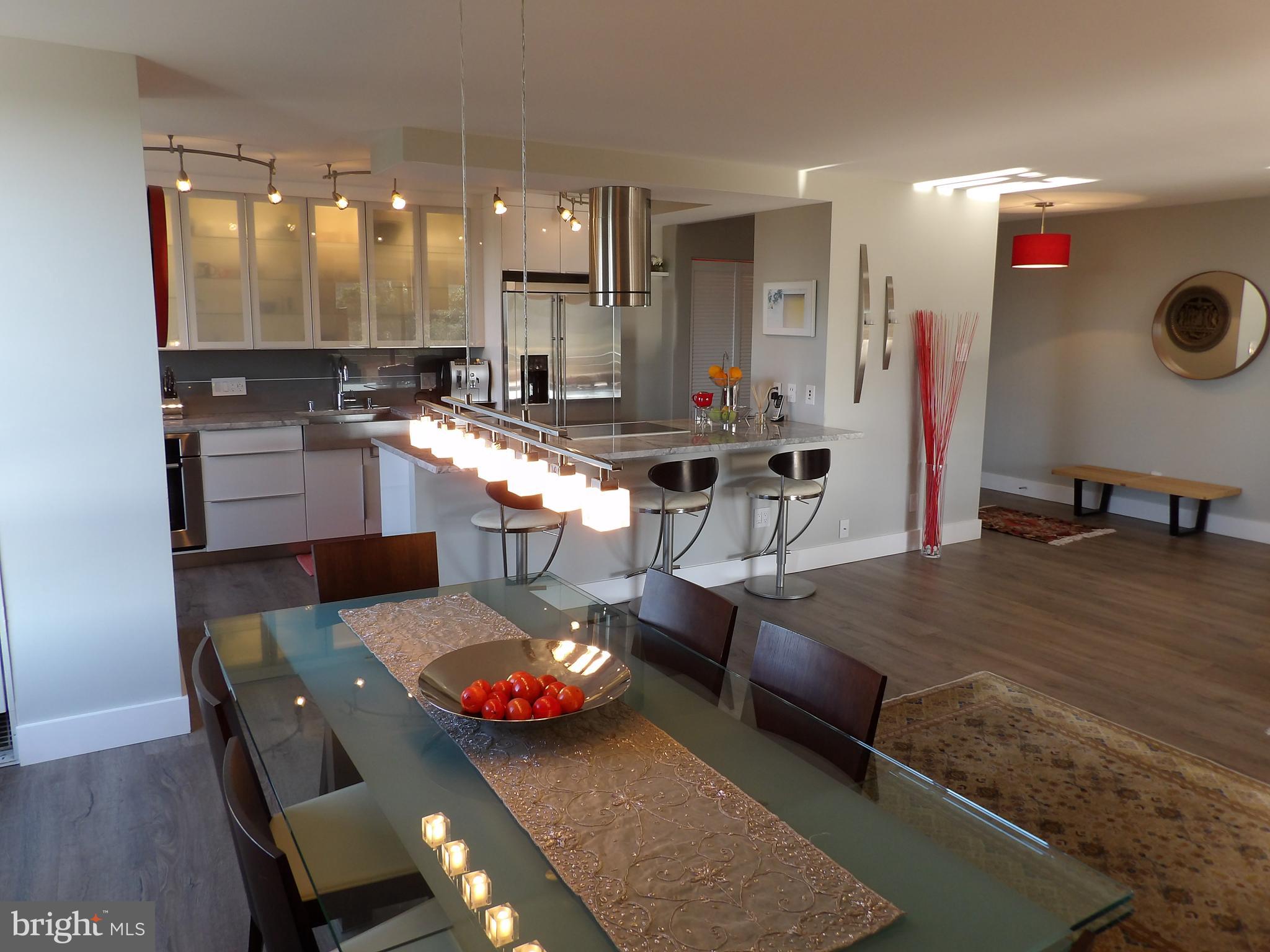 1800 Old Meadow Road, Unit 902 McLean, VA 22102 - Photo 25 of 67 a kitchen with stainless steel appliances kitchen island granite countertop a table and chairs in it