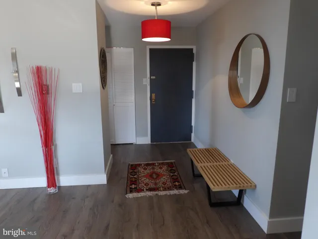 a living room with stainless steel appliances furniture a rug and a large window