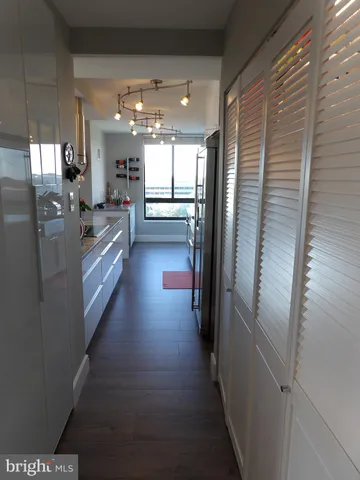 a kitchen with granite countertop a refrigerator a stove and a sink with wooden floor