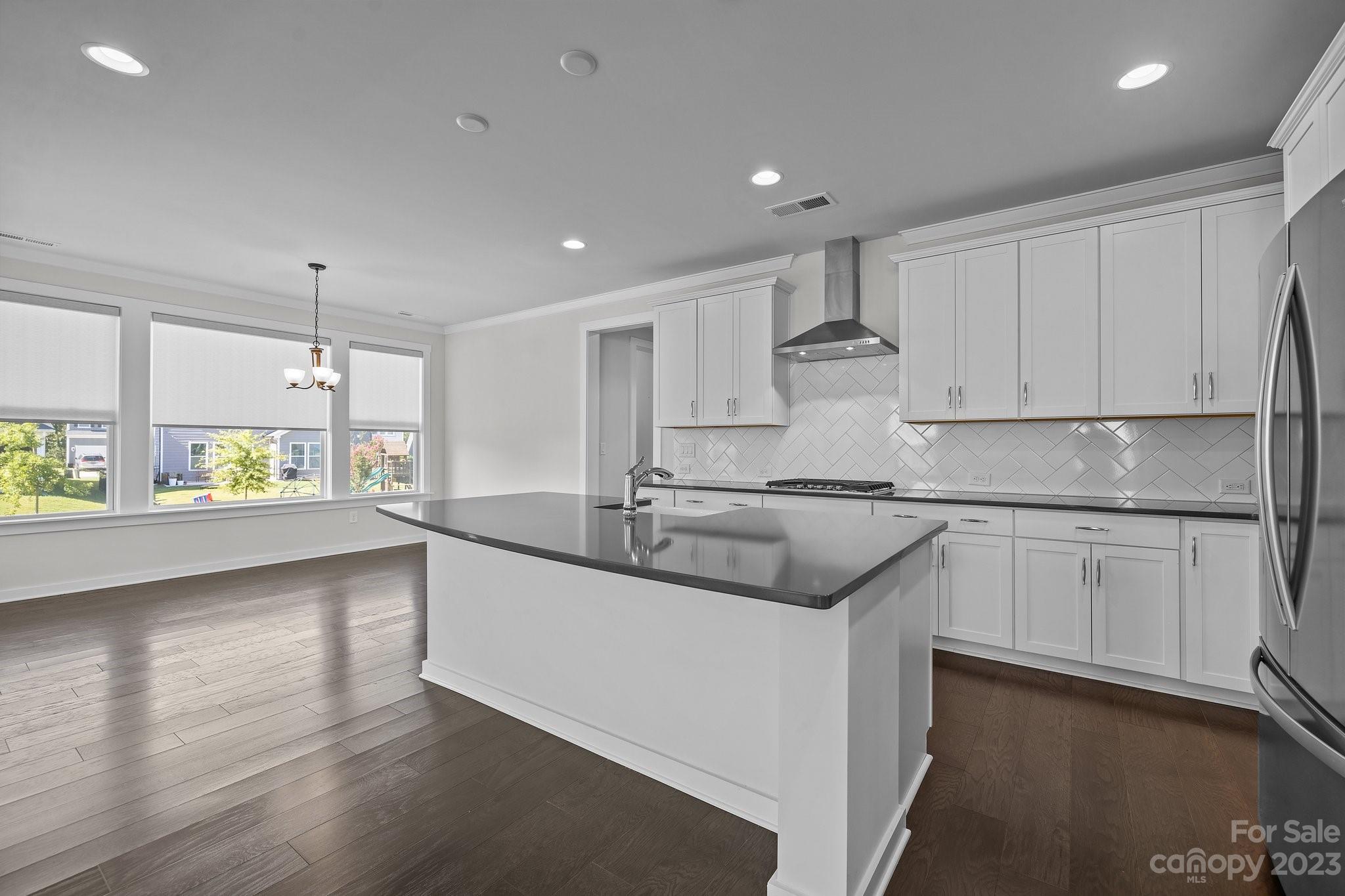 1256 Therns Ferry Drive Fort Mill, SC 29708 - Photo 12 of 47 a kitchen with stainless steel appliances granite countertop a sink stove and white cabinets with wooden floor