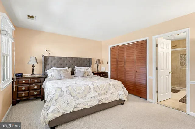 a bedroom with a bed a table and walk in closet