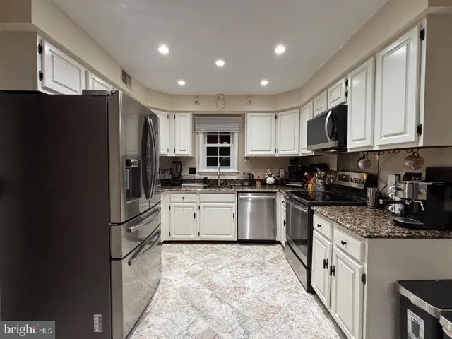 a kitchen with a refrigerator a sink and a stove top oven