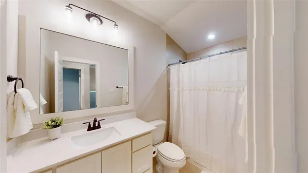 a bathroom with a sink a toilet a mirror and vanity