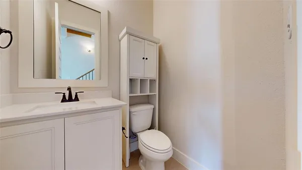 a bathroom with a granite countertop toilet sink and mirror