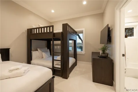 a bedroom with a bed and a flat tv screen on dresser
