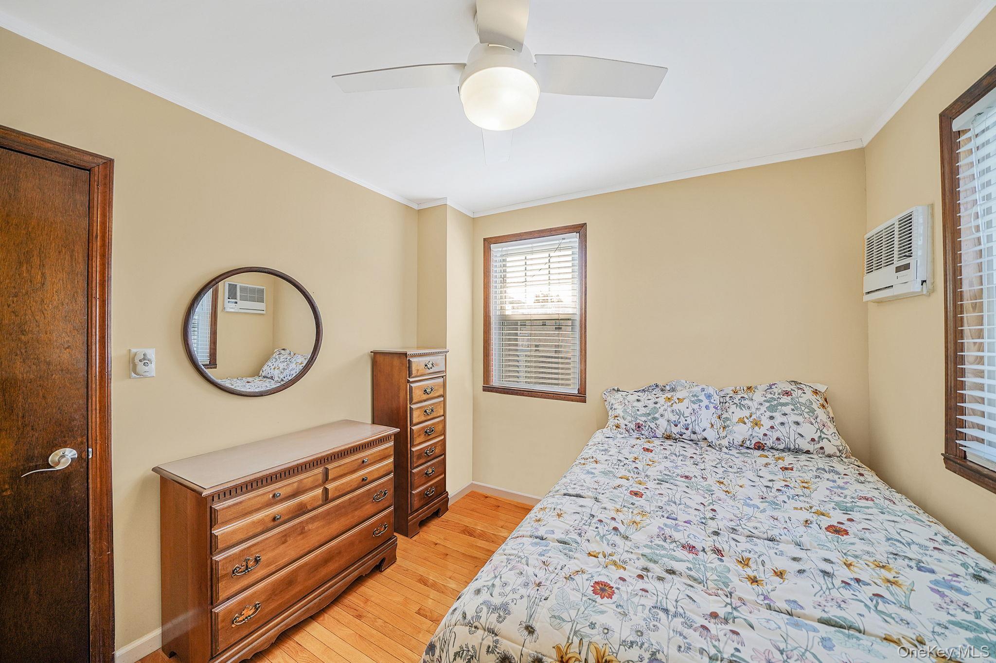 256-12 87th Road Floral Park, NY 11001 - Photo 18 of 33 a bedroom with a bed a mirror and a window