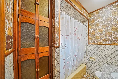 a bathroom with a sink a toilet and shower curtain