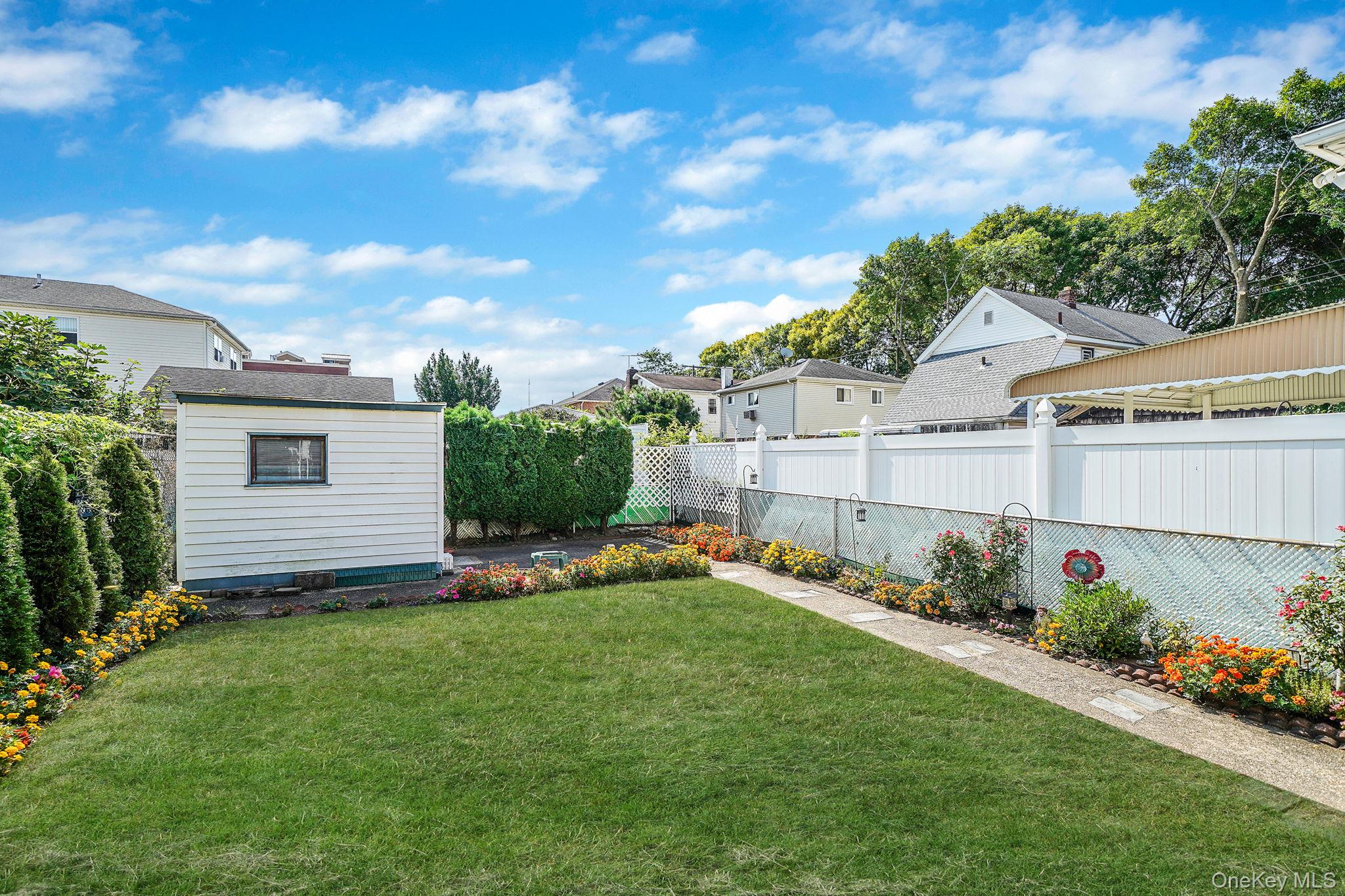 256-12 87th Road Floral Park, NY 11001 - Photo 30 of 33 a view of a backyard with plants and a patio