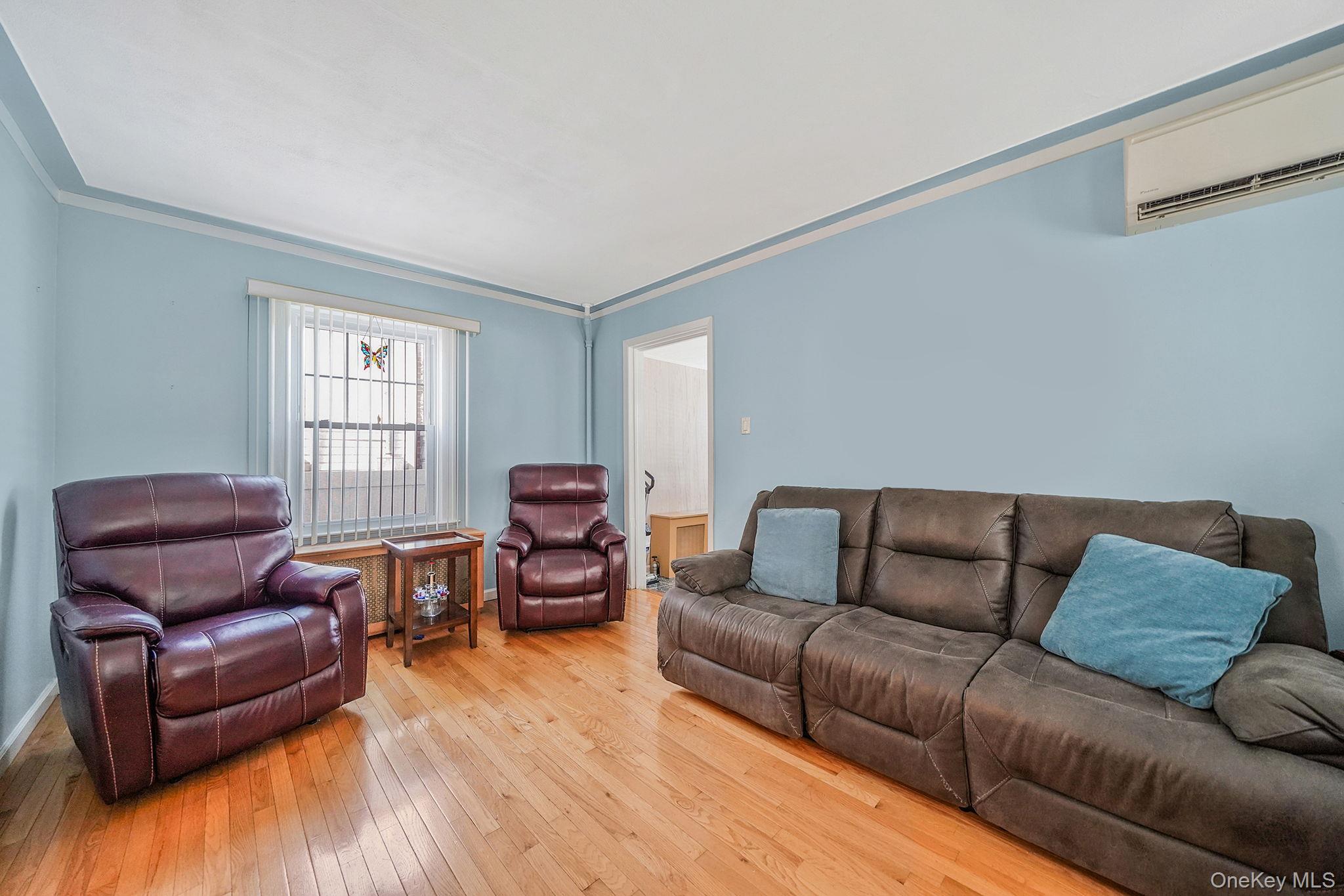 256-12 87th Road Floral Park, NY 11001 - Photo 6 of 33 a living room with a couch wooden floor and a window