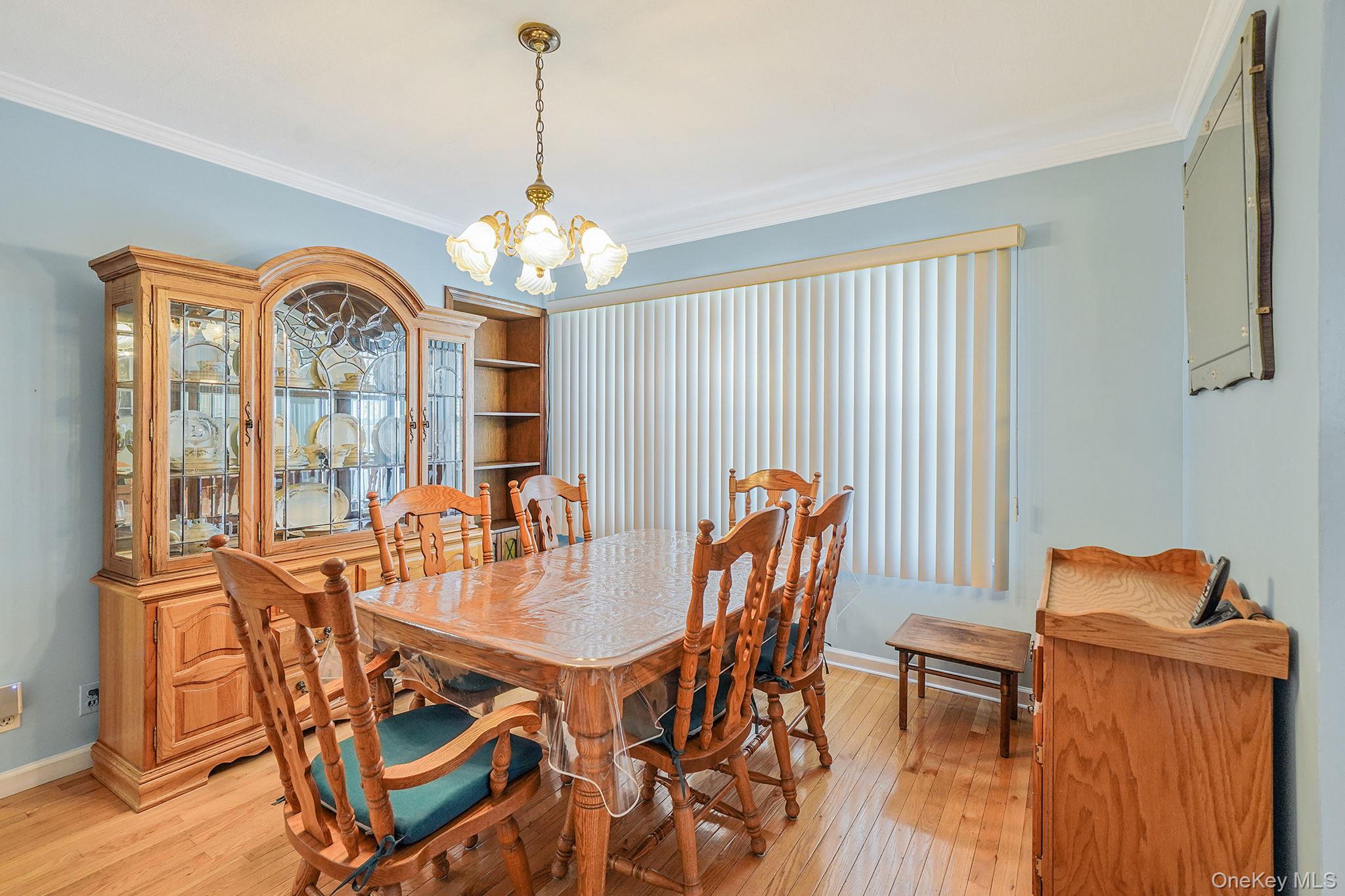 256-12 87th Road Floral Park, NY 11001 - Photo 8 of 33 a dining room with furniture a chandelier and wooden floor