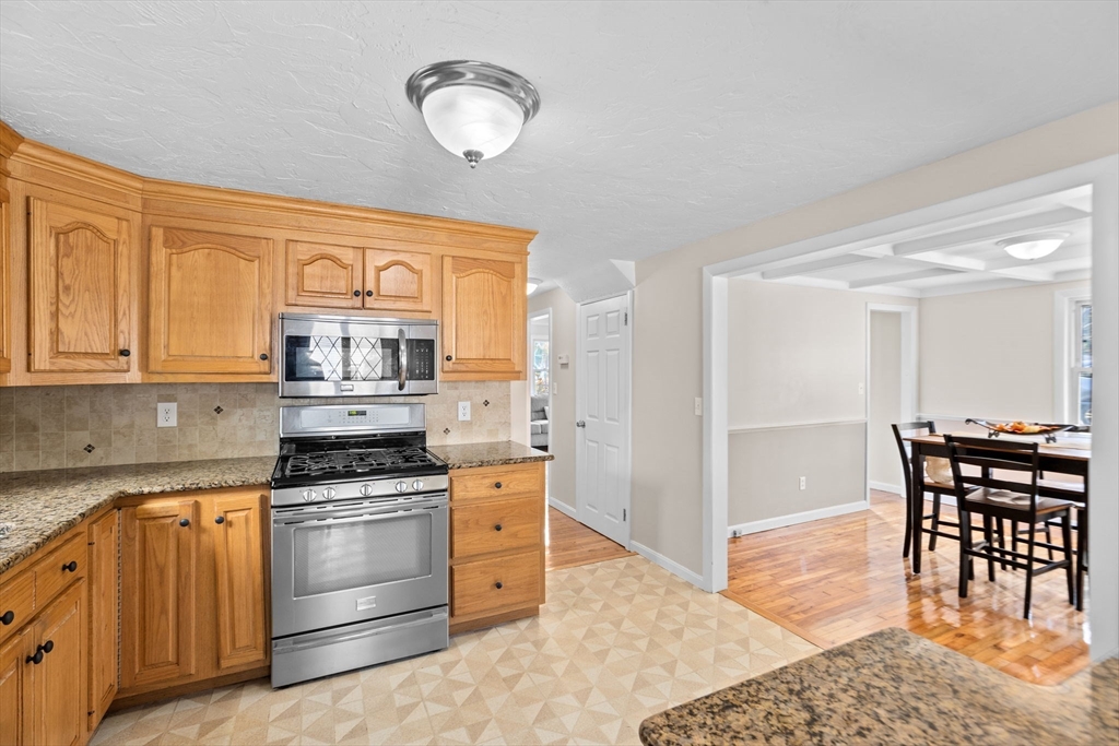 35 Red Jacket Road Weymouth, MA 02190 - Photo 8 of 33 a kitchen with stainless steel appliances granite countertop a stove a sink dishwasher and white cabinets with wooden floor