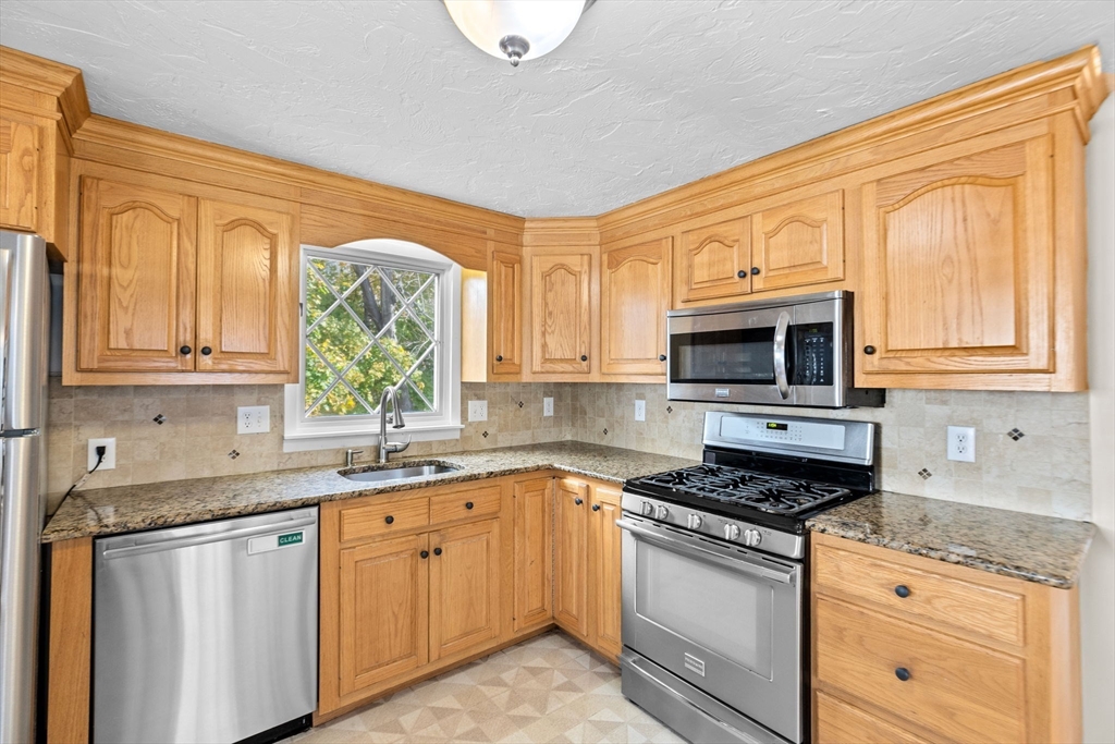 35 Red Jacket Road Weymouth, MA 02190 - Photo 10 of 33 a kitchen with stainless steel appliances granite countertop a sink a stove and cabinets