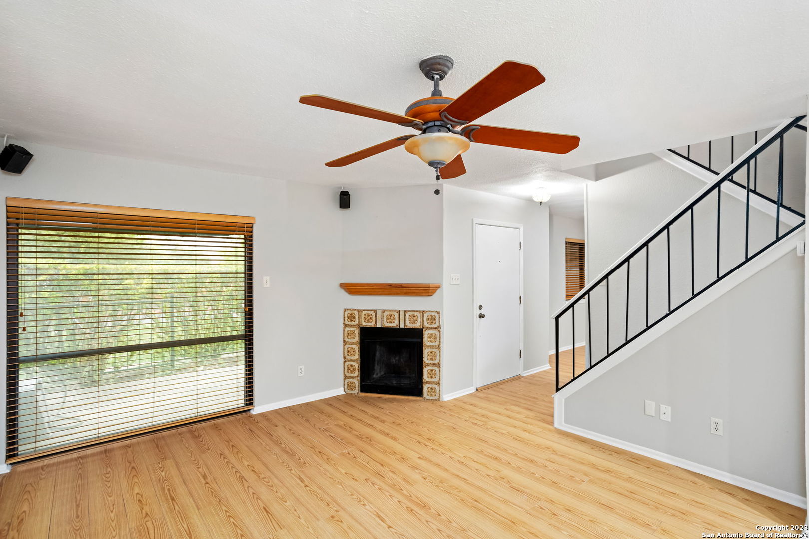 a view of empty room with fireplace and fan