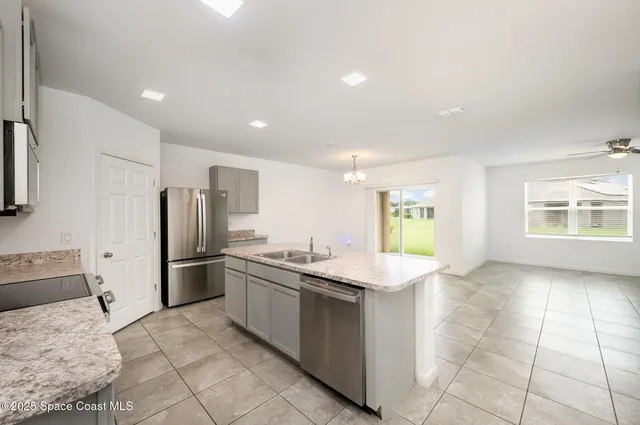 a kitchen with stainless steel appliances granite countertop a sink and a refrigerator