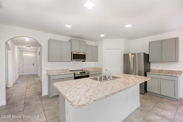 a kitchen with stainless steel appliances granite countertop a sink stove and refrigerator