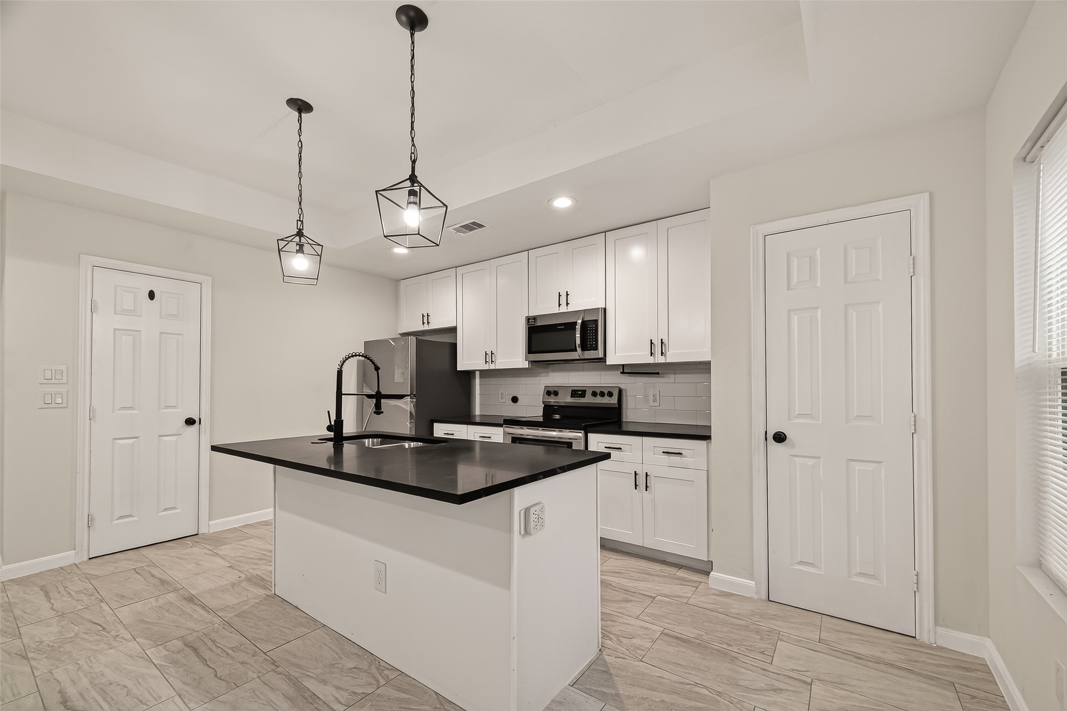 4302 Hirsch Road, Unit B Houston, TX 77026 - Photo 11 of 30 a kitchen with kitchen island granite countertop a sink a counter space appliances and cabinets