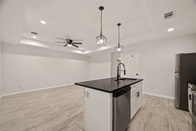 a kitchen with kitchen island a sink appliances and wooden floor