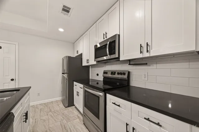 a kitchen with stainless steel appliances a stove microwave and refrigerator