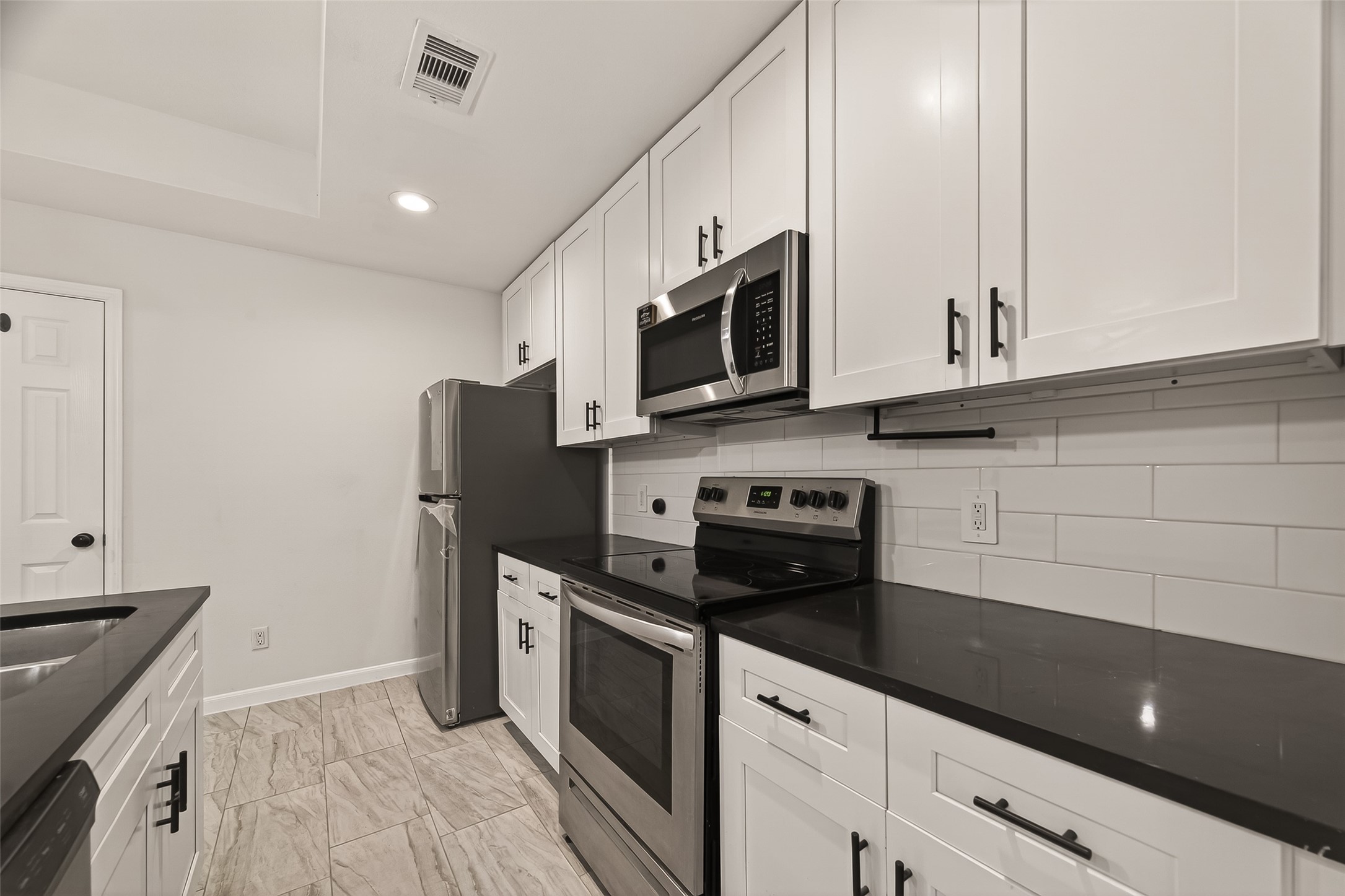 4302 Hirsch Road, Unit B Houston, TX 77026 - Photo 13 of 30 a kitchen with stainless steel appliances a stove microwave and refrigerator