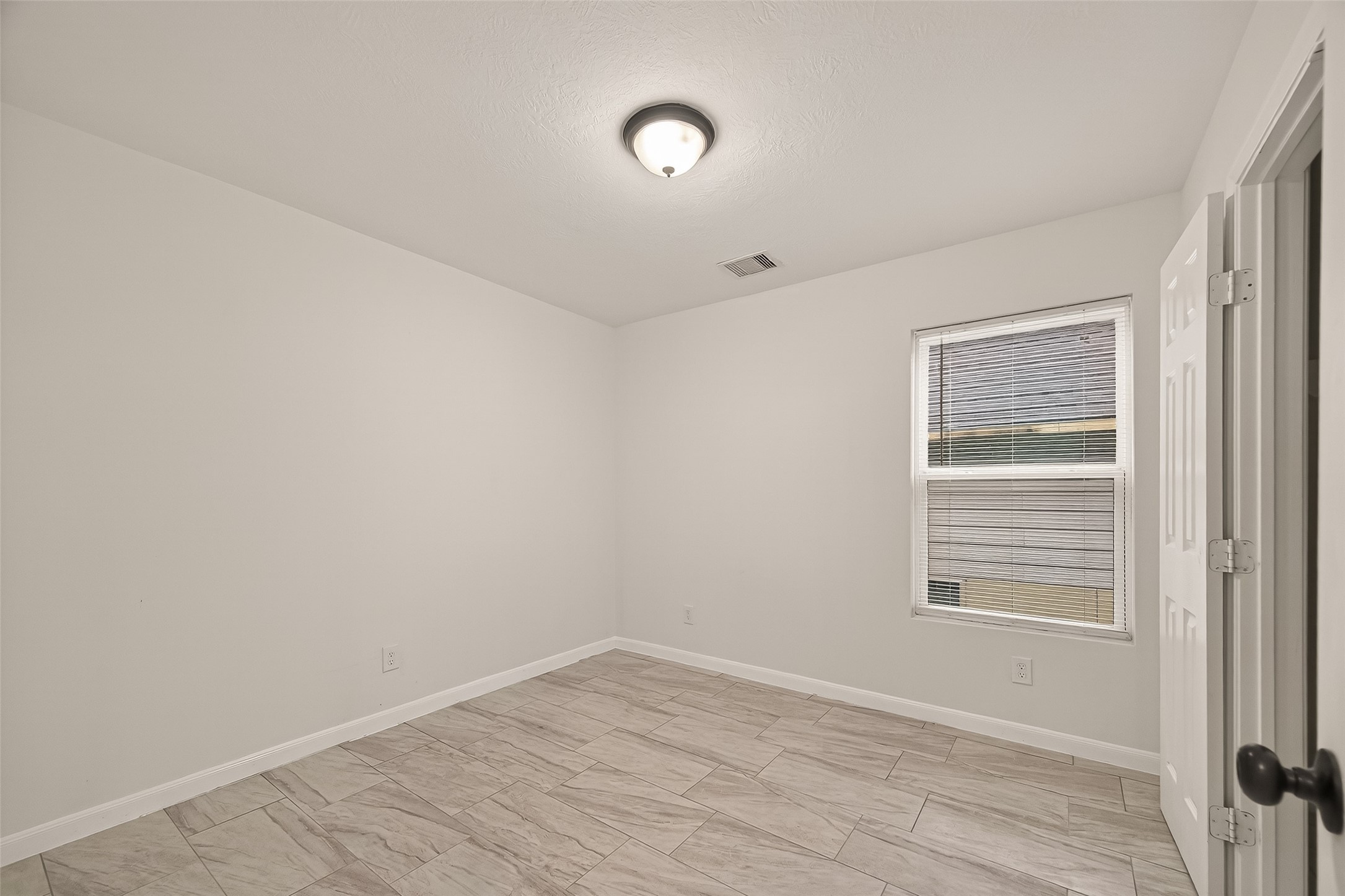 4302 Hirsch Road, Unit B Houston, TX 77026 - Photo 19 of 30 a view of an empty room with wooden floor and a window