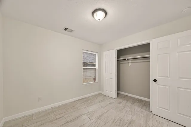 an empty room with closet and windows