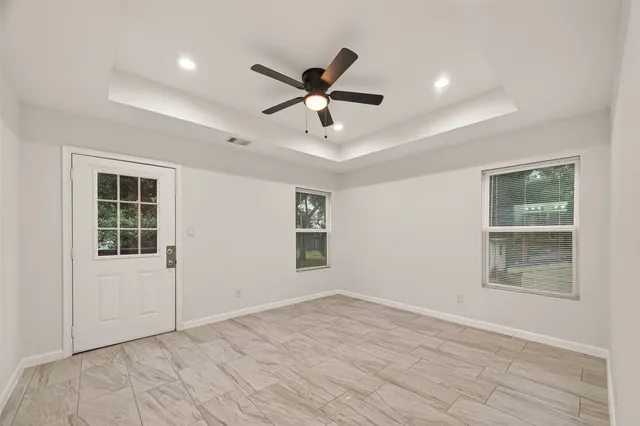 a view of an empty room with a window and wooden floor
