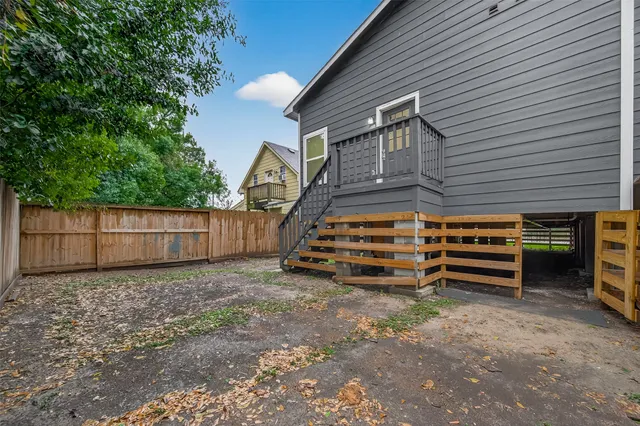 a backyard of a house with a small barn and wooden fence
