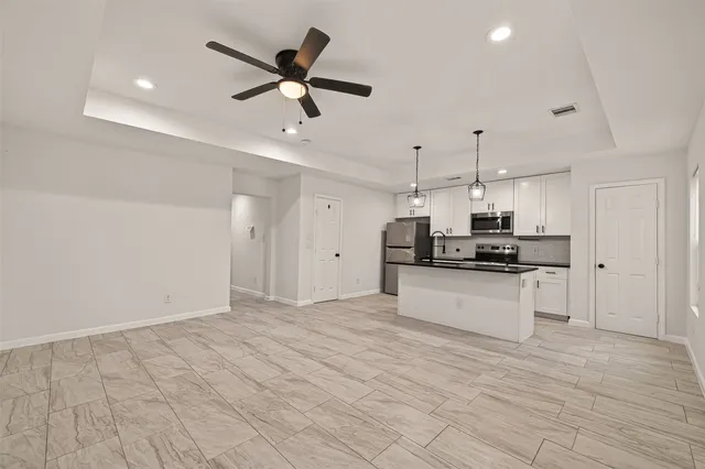 a view of kitchen with stainless steel appliances refrigerator stove microwave and cabinets