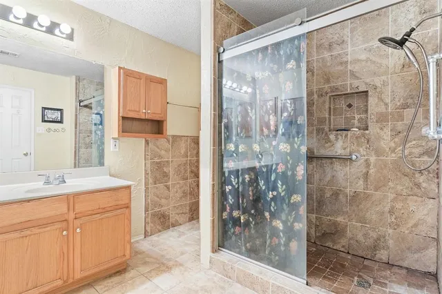 a bathroom with a shower and a sink a mirror