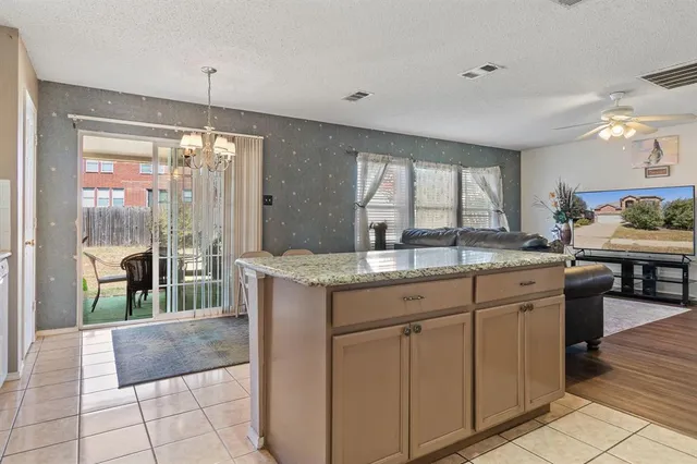 a kitchen with granite countertop a stove a sink and a refrigerator