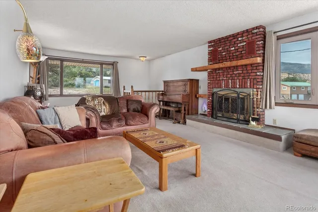 a living room with furniture a fireplace and a large window