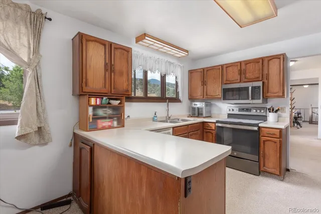 a kitchen with stainless steel appliances a stove sink microwave and cabinets